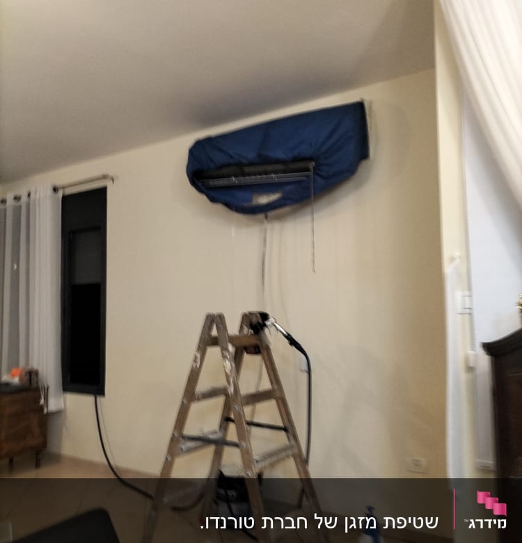 מזגן מכוסה בכיסוי כחול עם סולם לידו